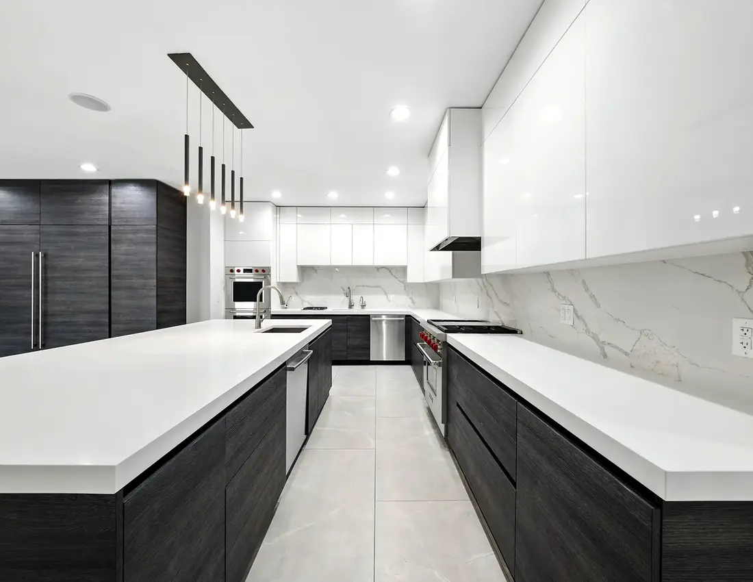 Hudson Yards galley kitchen with modern luxury interior, white countertops, and dark cabinetry.